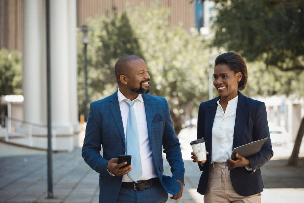 istock Two colleagues walking together and talking 1425163883