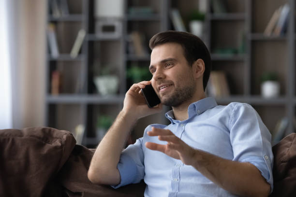 istock Smiling young handsome man holding pleasant telephone call conversation. 1425167323