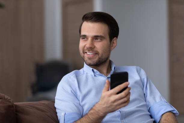 istock Happy relaxed young dreaming, holding cellphone in hands. 1425167324