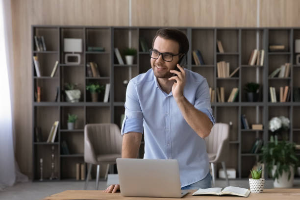 istock Smiling young businessman holding phone call conversation. 1425167397