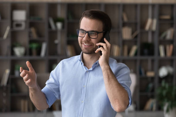 Happy young businessman holding phone call conversation.