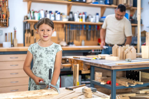 istock Girl cutting wooden plank 1425169523