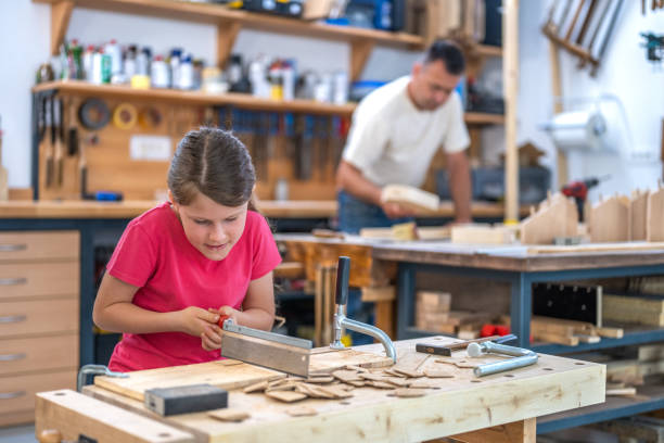 istock Girl cutting wooden plank 1425169524