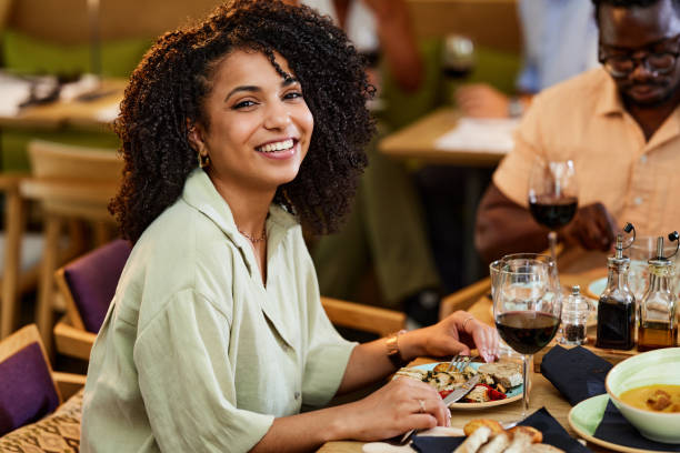 istock A smiling Hispanic girl is having dinner in a restaurant. 1425170392