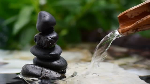 Zen stones, bamboo trough, flowing water, spa concept.