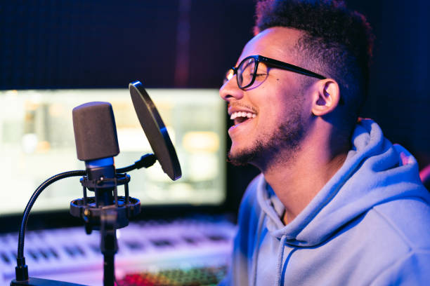 istock Young male singer in recording studio performing in neon lights 1425171623