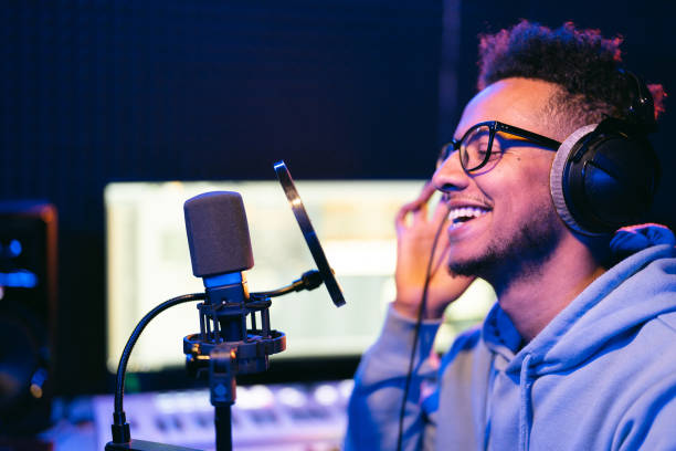 istock Young male singer in recording studio performing in neon lights 1425171647