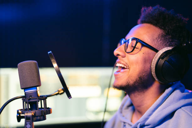 istock Young male singer in recording studio performing in neon lights 1425171666