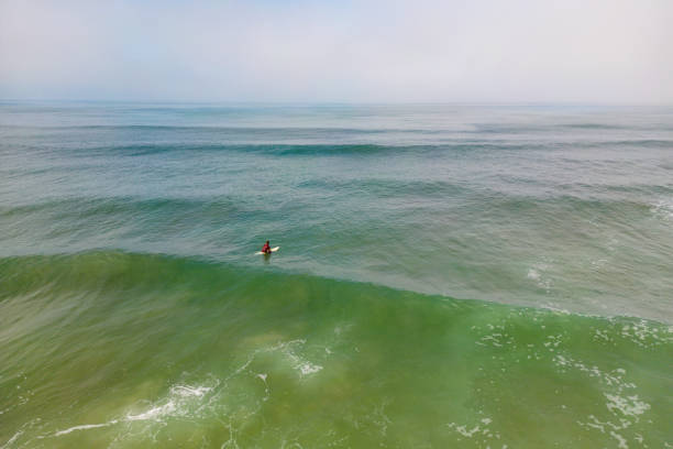 Aerial side shot of a surfer in the wavy sea, Murtosa, Aveiro - Portugal.