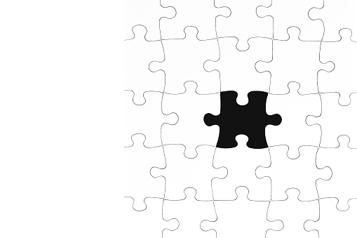 Photo of white jigsaw puzzle with one missing piece, copy space for text