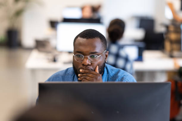 istock Young African businessman busy working on computer at coworking office 1425175210