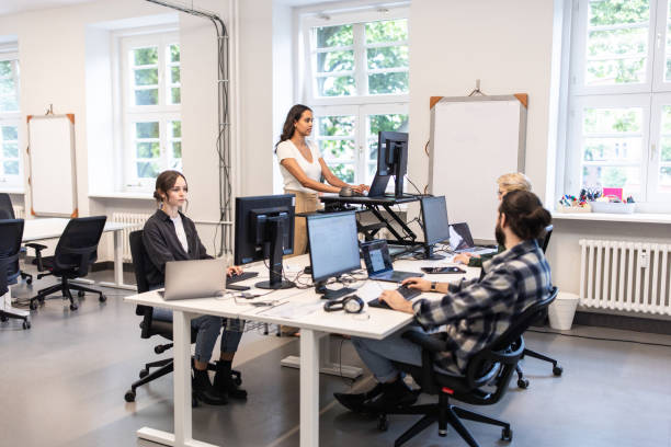 istock Group of professionals working at their desks in an open plan office 1425175387