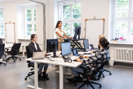 Group of professionals working at their desks in an open plan office. Startup business people working at a modern office.