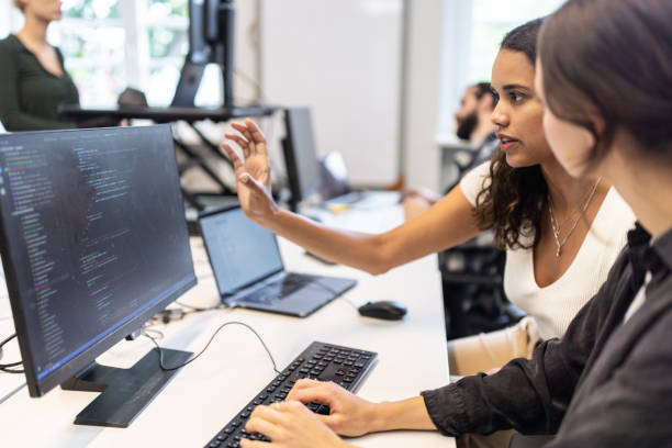 istock Two businesswomen working together at coworking desk using computer 1425175413
