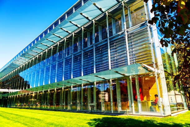 Cambridge, Massachusetts, USA - September 15, 2022: Low angle view of the main Cambridge Public Library building and it's modern glass exterior. The building is of an innovative green environment-friendlly and energy efficient design and opened in 2009. Saturated and bright colors.