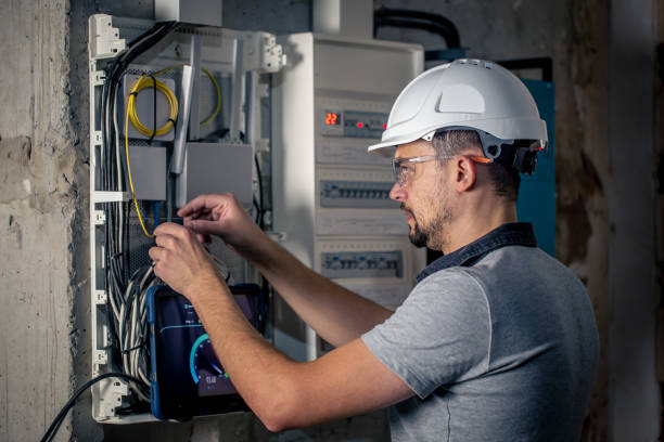 istock Man, an electrical technician working in a switchboard with fuses, uses a tablet. 1425179205