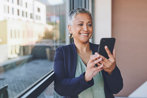 Senior, phone and happy woman from India with mobile looking at web content with a smile. Happy elderly Indian female using technology to scroll internet and social media app or to start a video call