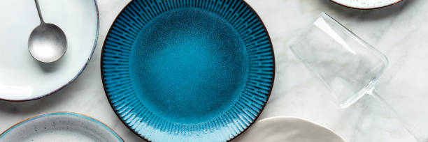 istock Modern tableware panorama with a vibrant blue plate, cutlery, and a wine glass 1425181752