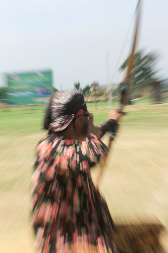 Yogyakarta, Indonesia - October 27, 2019: Jemparingan, a traditional archery sport from Java, Indonesia. Archers wear traditional Batik clothes and sit cross-legged while shooting