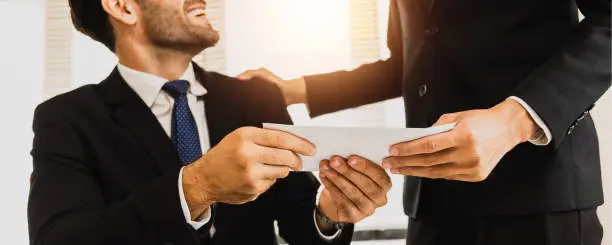 Photo of close up hand of employee receive bonus from manager