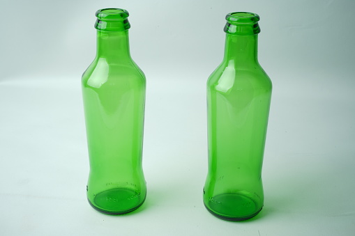 Glass bottles of soda on white background.