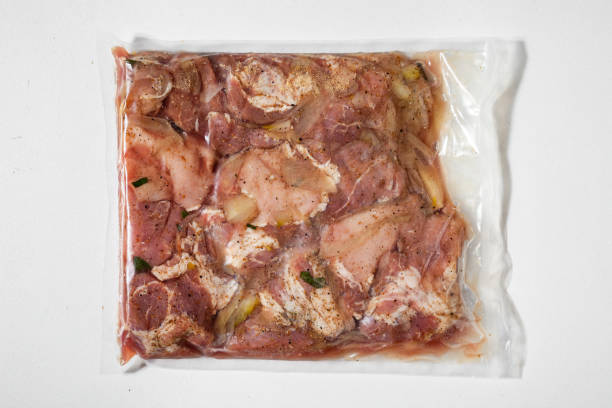 istock Vacuum packed raw marinated meat with onions, peppers and salt on a white background 1425186991