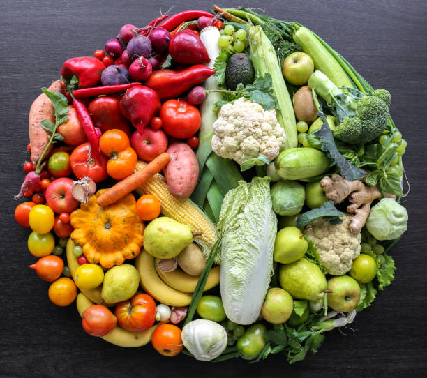 istock Various vegetables and fruits laid out in a circle on a dark background. 1425187285