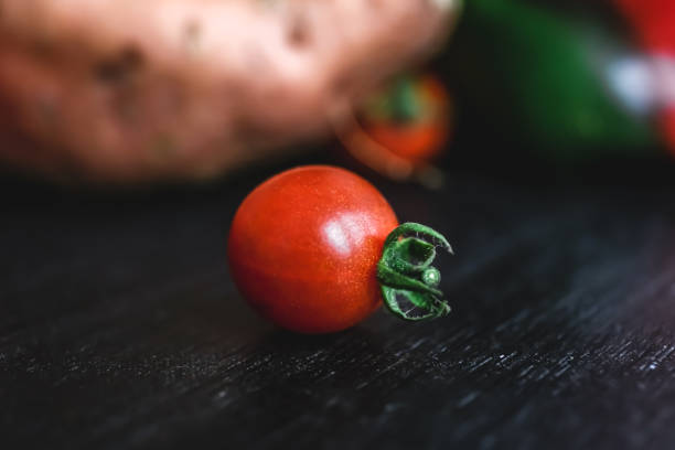 Cherry tomato close-up on a wooden surface on a blurred background, macro shot.