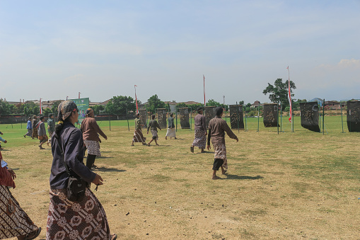 Yogyakarta, Indonesia - October 27, 2019: Jemparingan, a traditional archery sport from Java, Indonesia. Archers wear traditional Batik clothes and sit cross-legged while shooting