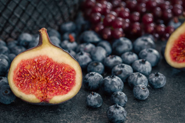 Composition with ripe figs in the cut and berries close-up, background with berries.