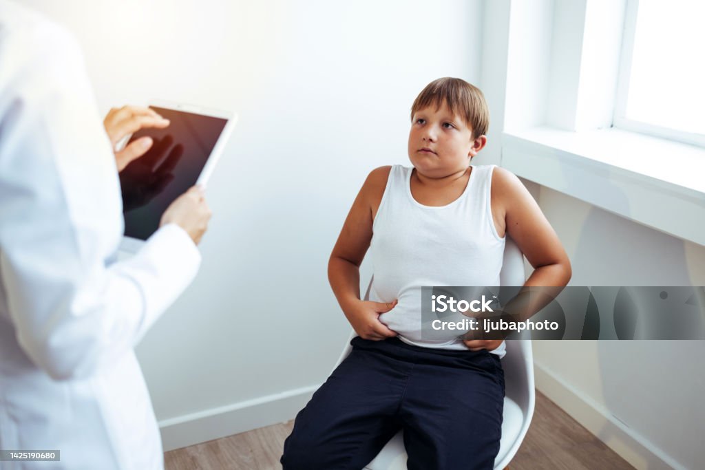 Obese child listening to nutritionist's recommendations. Sad Obese child listening to nutritionist's recommendations. Obesity Stock Photo