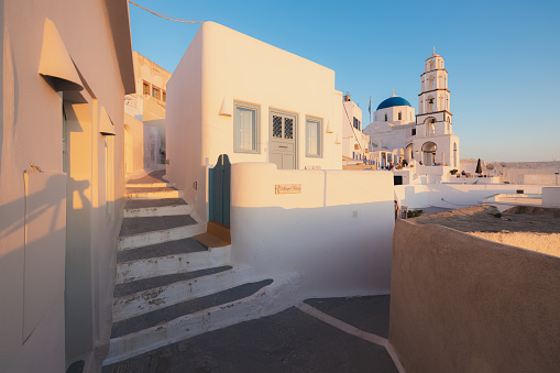 Pyrgos, Greece - September 12 2022: The traditional blue dome Greek Orthodox Holy Church of the Transfiguration of the Savior during golden hour in the quaint village of Pyrgos Kallistis on the island of Santorini.