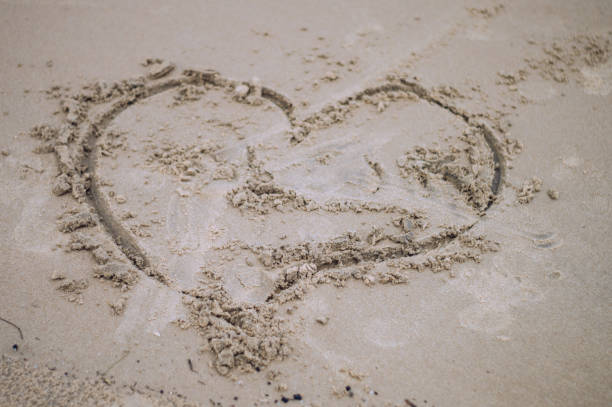 знак любви на песке. символ сердца любви в песке на тропическом пляже. праздники фоны текстуры. пури, одиша, индия - sandy brown day the americas north america стоковые фото и изображения