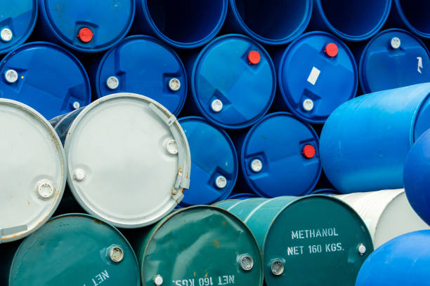 Old chemical barrels. Stack of blue methanol or methyl alcohol drum. Steel chemical tank. Toxic waste. Chemical barrel with toxic warning symbol. Industrial waste in drum. Hazard waste storage. stock photo