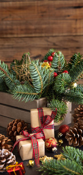 istock Wrapped gift boxes between Christmas decorations, pine cones and green fir branches 1425204095