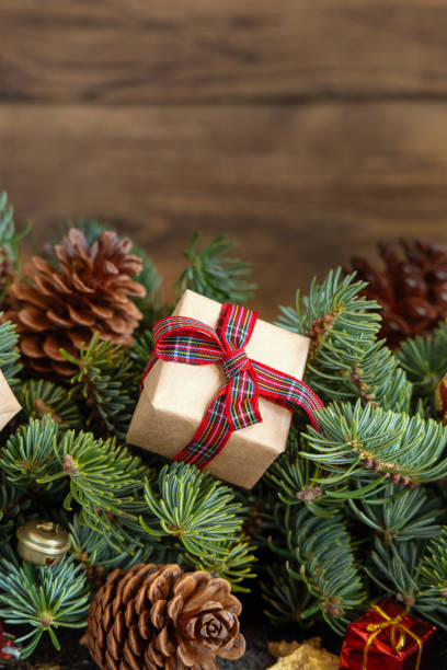 istock Wrapped gift boxes on reen fir branches near Christmas decorations and pine cones 1425204101