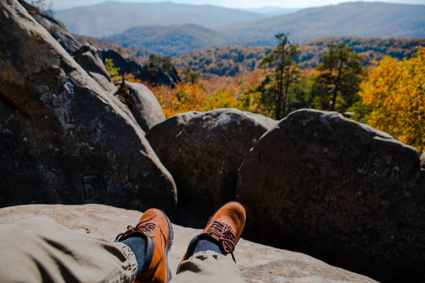 istock hiking concept men legs in boots on the rock 1425206920