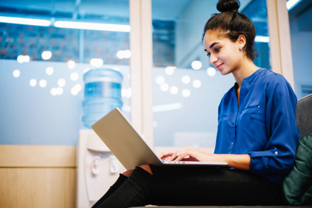 istock Focused young ethnic woman working on laptop in modern workplace 1425207227