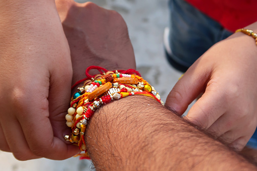 Stock photo showing close-up view of Indian man taking part in the Hindu festival of brotherhood and love, Raksha Bandhan ceremony. During this annual event, held on the last day of the Hindu lunar calendar month of Shraavana, sisters tie a rakhi, string bracelet, on their brothers' wrists to signify protection.