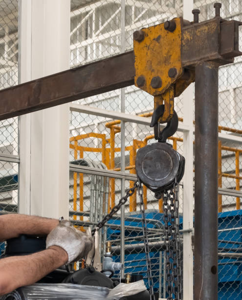 work in an industrial plant man wearing white gloves Assemble and lock the chain to the machine.  safety, machinery, working at height stock photo