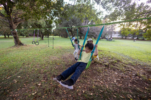 istock Family playing on swing in public park 1425208837
