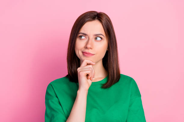 Photo portrait of nice young lady skeptical look empty space not believe doubt dressed trendy green look isolated on pink color background stock photo