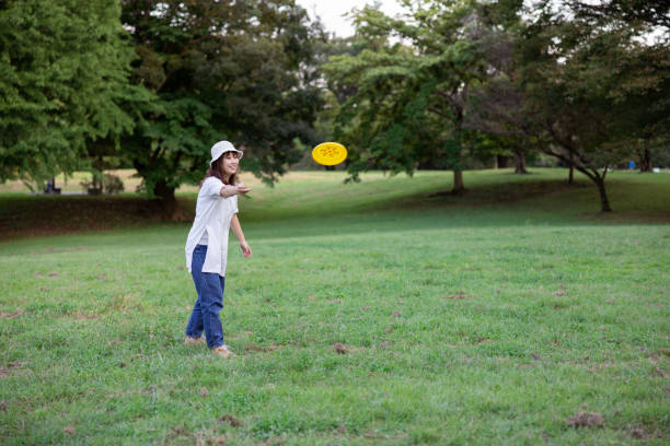 istock Mother throwing flying disc in green field in public park 1425209581