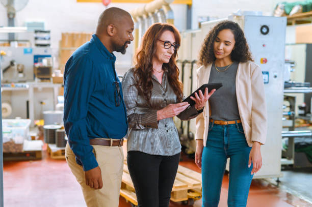 istock Business, building and management warehouse team on a tablet working on a project. Diversity of teamwork and collaboration of a tech and industrial factory stock workers with digital data research 1425210220