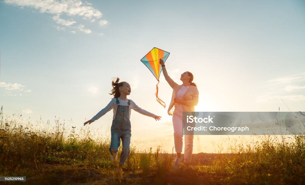 Happy family at sunset Happy family running through field with kite. Kite - Toy Stock Photo