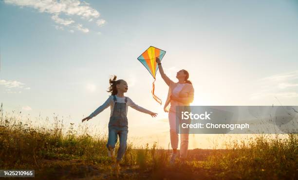 Happy Family At Sunset Stock Photo - Download Image Now - Kite - Toy, Autumn, Mother