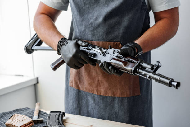 istock Close up of young man in apron disassembling a gun above the table 1425211361