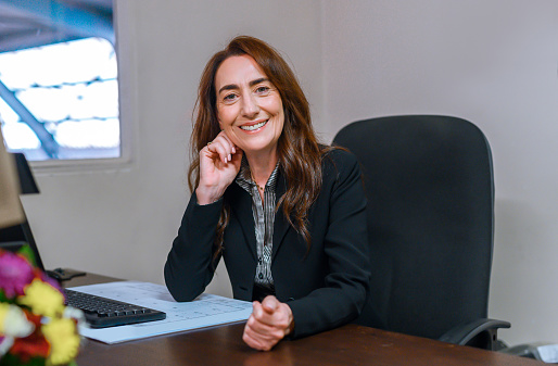 Portrait of mature business woman, Manager or leader happy smile in office with a positive attitude ready to work. Confident corporate female employee show motivation and happiness in the workplace