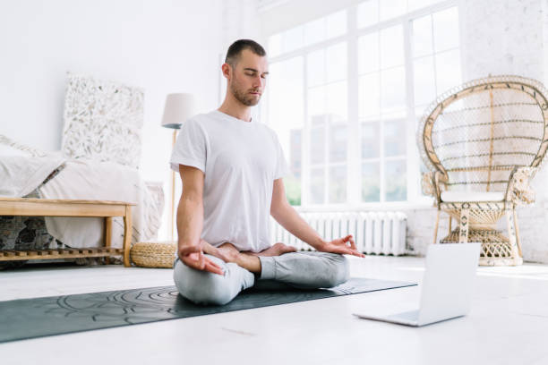 istock Calm tranquil caucasian male with closed eyes enjoying meditation using laptop computer for listening online lesson, man spending time on spirituality and healthy lifestyle practice yoga at home 1425212416