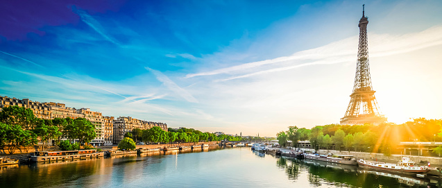 Paris Eiffel Tower and city of Paris reflecting in river Seine at sunrise in Paris, France. Eiffel Tower is one of the most iconic landmarks of Paris., web banner